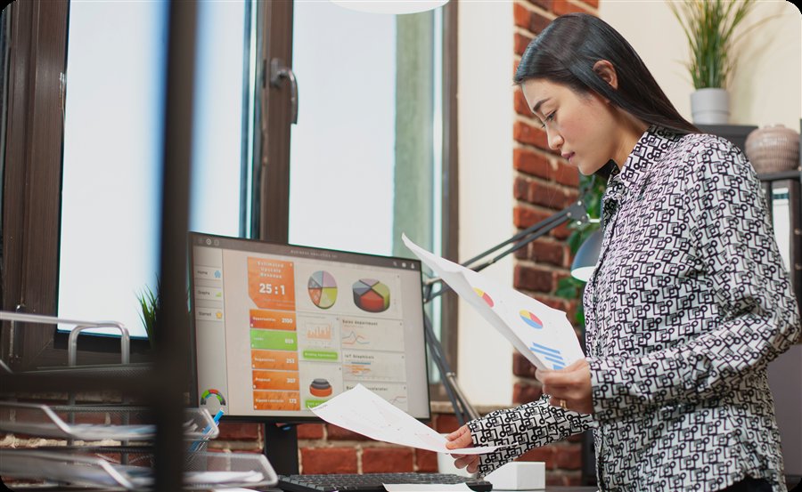 A finance professional reviewing payroll reports at her desk
